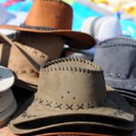 Variety of brown leather hats displayed for sale at a local market.