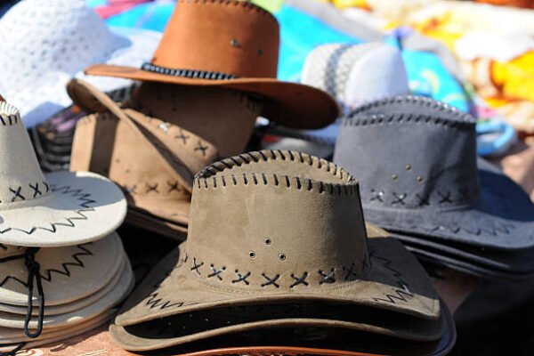 Variety of brown leather hats displayed for sale at a local market.