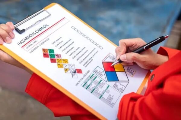 "Person filling out a hazardous chemical safety checklist on a clipboard"