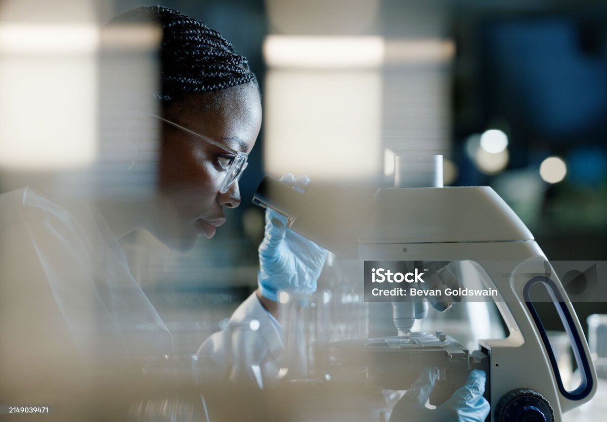 "Female scientist using a microscope in a laboratory for research"