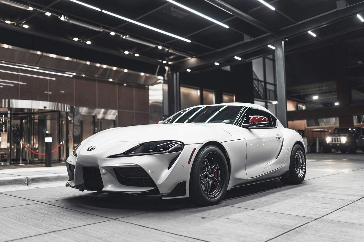 White Toyota sports car parked in a modern garage.