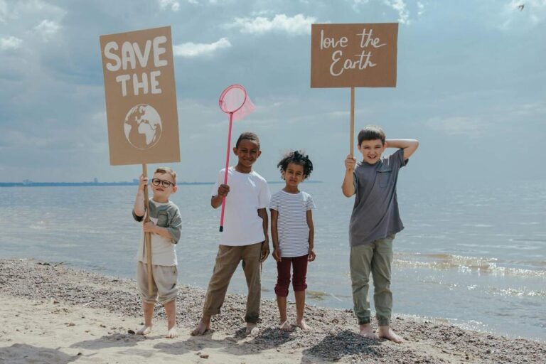 "Four diverse children standing on a beach holding eco-friendly signs for Earth conservation"