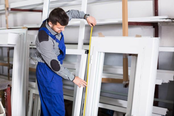  "Factory worker measuring a door frame with a tape measure"