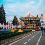 "Colorful carousel and decorated park with holiday lights during winter festival"