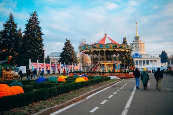 "Colorful carousel and decorated park with holiday lights during winter festival"