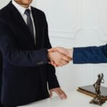 "Business professionals in formal suits shaking hands, symbolizing a successful agreement or partnership"