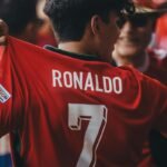 A fan wearing a red Ronaldo jersey with the number 7 at a football event.