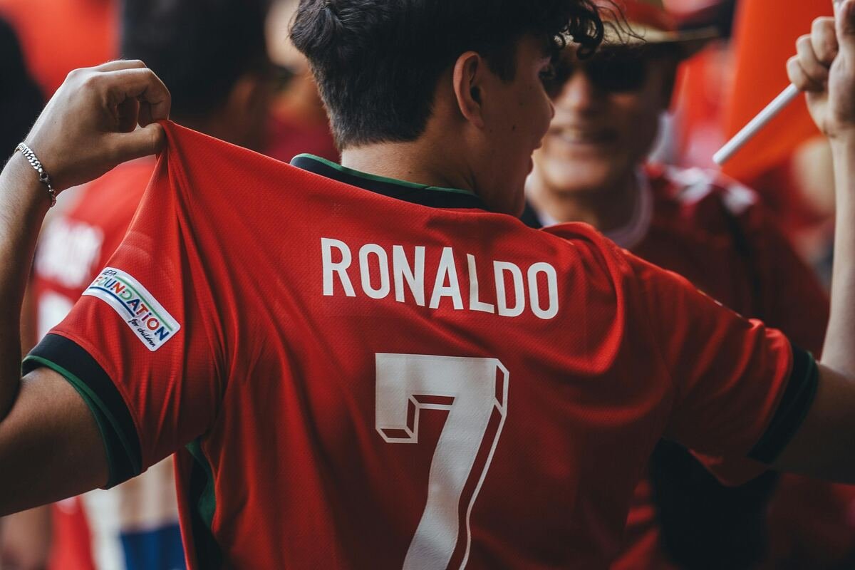 A fan wearing a red Ronaldo jersey with the number 7 at a football event.