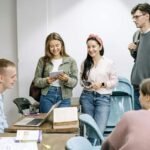Group of college students interacting and sharing notes in a classroom setting.