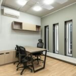 Modern office space with ergonomic chairs, wooden table, and stylish decor."