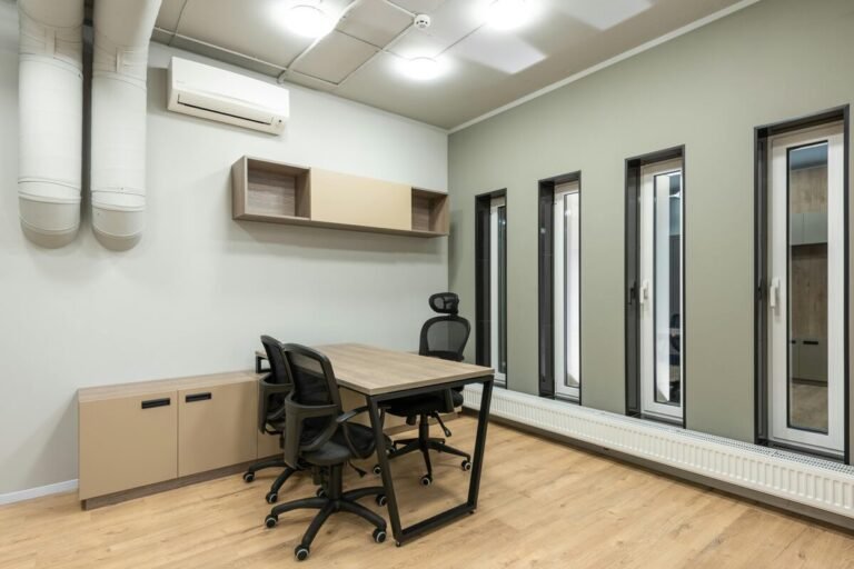 Modern office space with ergonomic chairs, wooden table, and stylish decor."